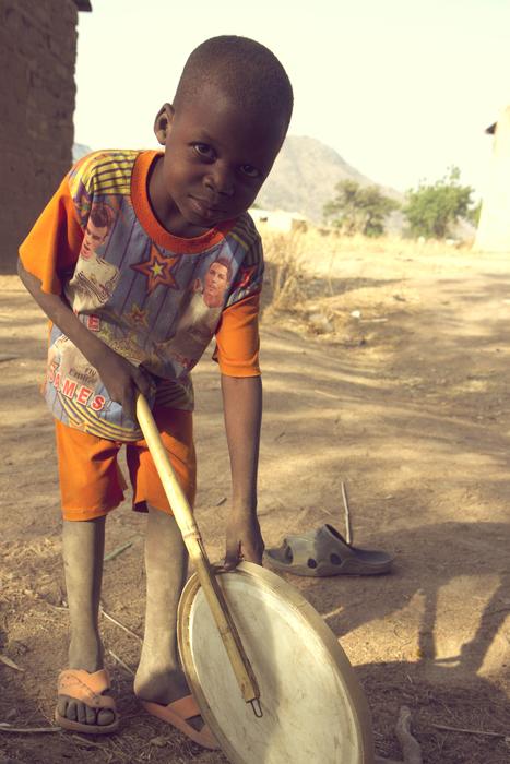 photo of boy on a street in a village in Nigeria