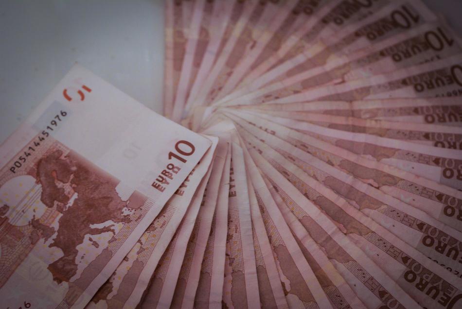 Fan of red and white '10' Euro banknotes, on the white surface