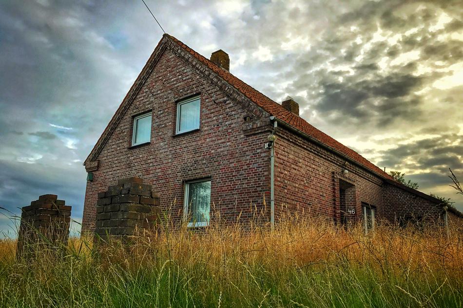 old brick building near a meadow with grass in germany