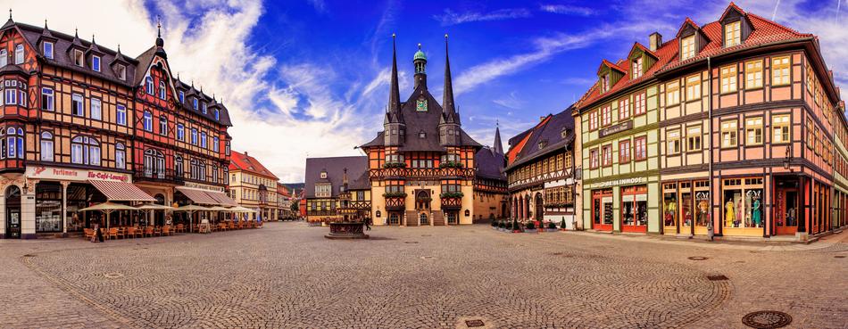 Beautiful and colorful marketplace, among the colorful houses, in Wenigerode, Germany, under the blue sky with clouds