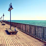 wooden benches under the lanterns on the pier