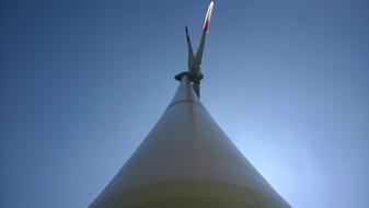 Low angle shot of the windmill, under the beautiful, gradient, blue sky