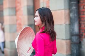photo of a vietnamese girl with a hat in her hand