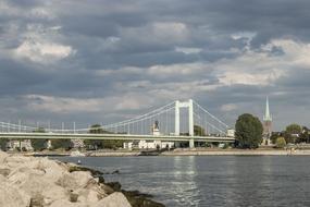 Landscape with the bridge, above the Rhine, among the green plants, in Cologne, Germany, under the clouds