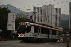 photo of a white tram on a street in Hong Kong