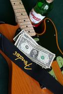 dollar bills and beer on Guitar