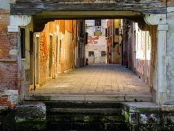 Colorful passage among the buildings in sunlight, in Venice, Italy