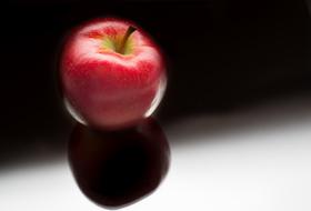 Shiny Red Apple on Black surface