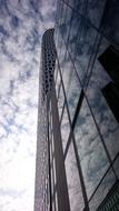 cloudy sky reflected in the glass facade of a modern building