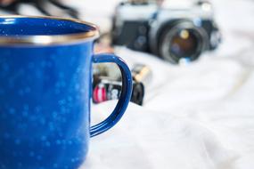 blue mug on the background of the old camera