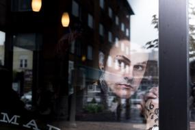 face behind the glass of a city cafe