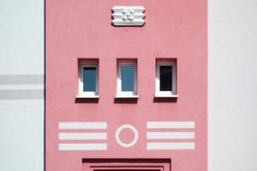 three rectangular windows on pink facade