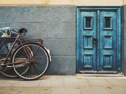 blue wooden doors and bicycles against the wall of the building