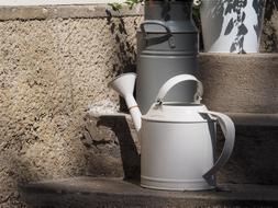 white metal watering can and gray metal can