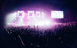 People crowd the spotlight of the stage concert