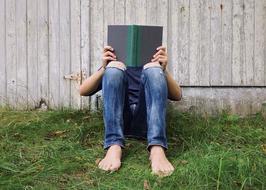 Person Young Reading book on green grass
