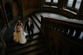 newlyweds descend the castle stairs