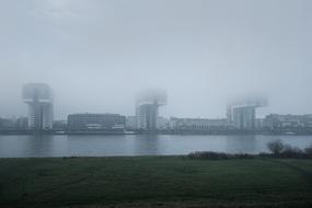 view from the river to the modern architecture of the city in the fog