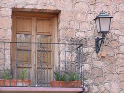 Beautiful and colorful, vintage balcony of the house, with the plants and lantern, in Spain