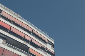 Corner of the the white and red building at blue sky background