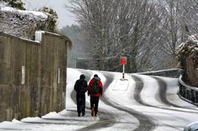 two men Walking uphill on road at winter