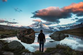 man looking at a mountain with a lake