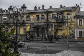 People on bus stop in front of grunge old building at evening, ukraine, Odessa