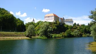 Beautiful and colorful castle on the shore of Kupa River, among the colorful plants, in Ozalj, Croatia