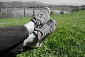 Sneakers on human feet over lawn, Relaxation