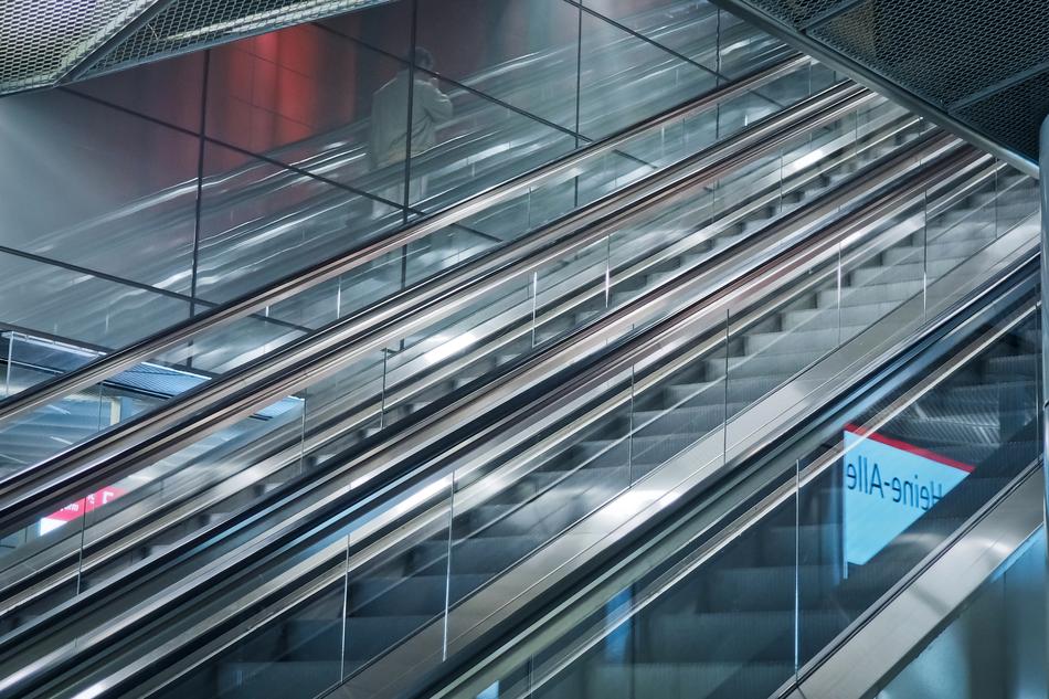 Close-up of the shiny escalator with the handrails and glass, in light, in DÃ¼sseldorf, Germany