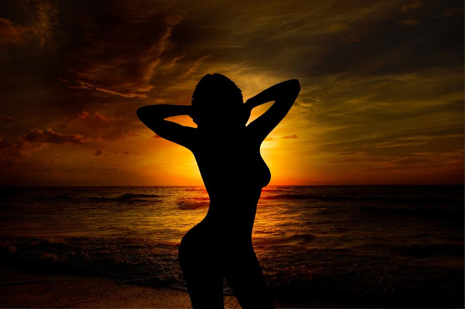A silhouette of a girl at sunset