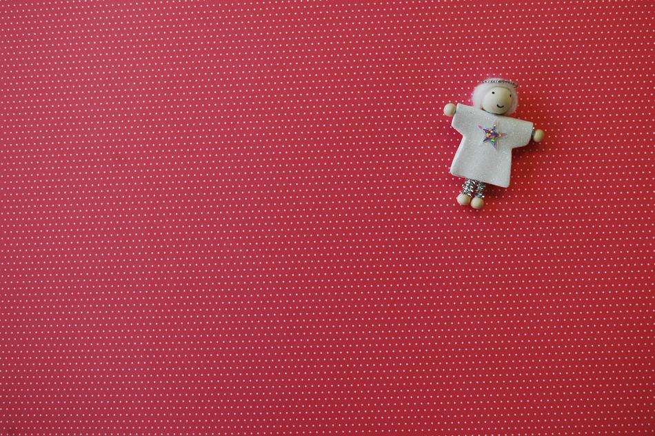 toy angel on a burgundy background