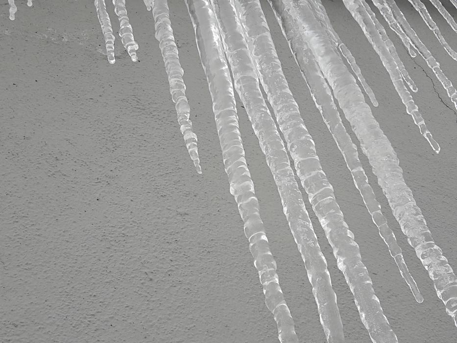 Beautiful icicles at grey background in winter