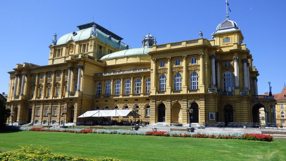 Beautiful building of the national theater among the colorful plants in Zagreb, Croatia