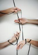 four Hands tied by black ribbon