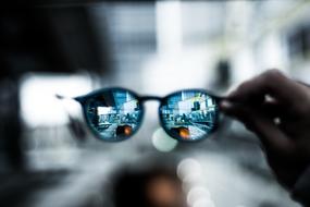 Close-up of the colorful and beautiful eyeglass in the hand, at bokeh background