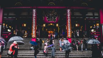 asian People with umbrellas on steps at building