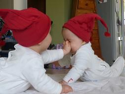 two newborn twins in christmas caps
