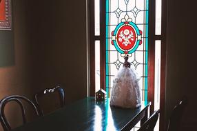 Beautiful kitchen table with the Barbie near the colorful patterned window