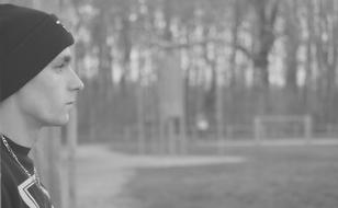 black and white photo profile of a young man in a park