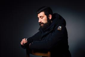 photo of a man in a black jacket on a chair
