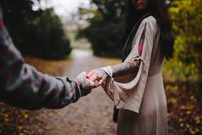 couple holding hands in autumn park