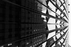 reflection of a skyscraper in the glass facade of a high-rise building