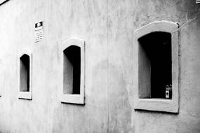 Black and white photo of the construction, with the windows, with the sign on the wall