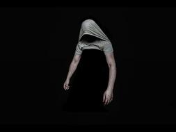 photo of a man with a t-shirt on his head in the dark