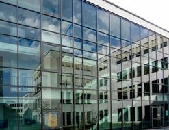 glass facade with a mirror image of an office building