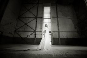 girl in a long white dress posing in an abandoned building