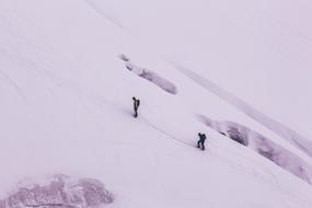 two Men climbing mountain on snowy winter