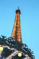 the tower behind the carousel in the amusement park