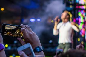 taking pictures of the singer on stage on the phone
